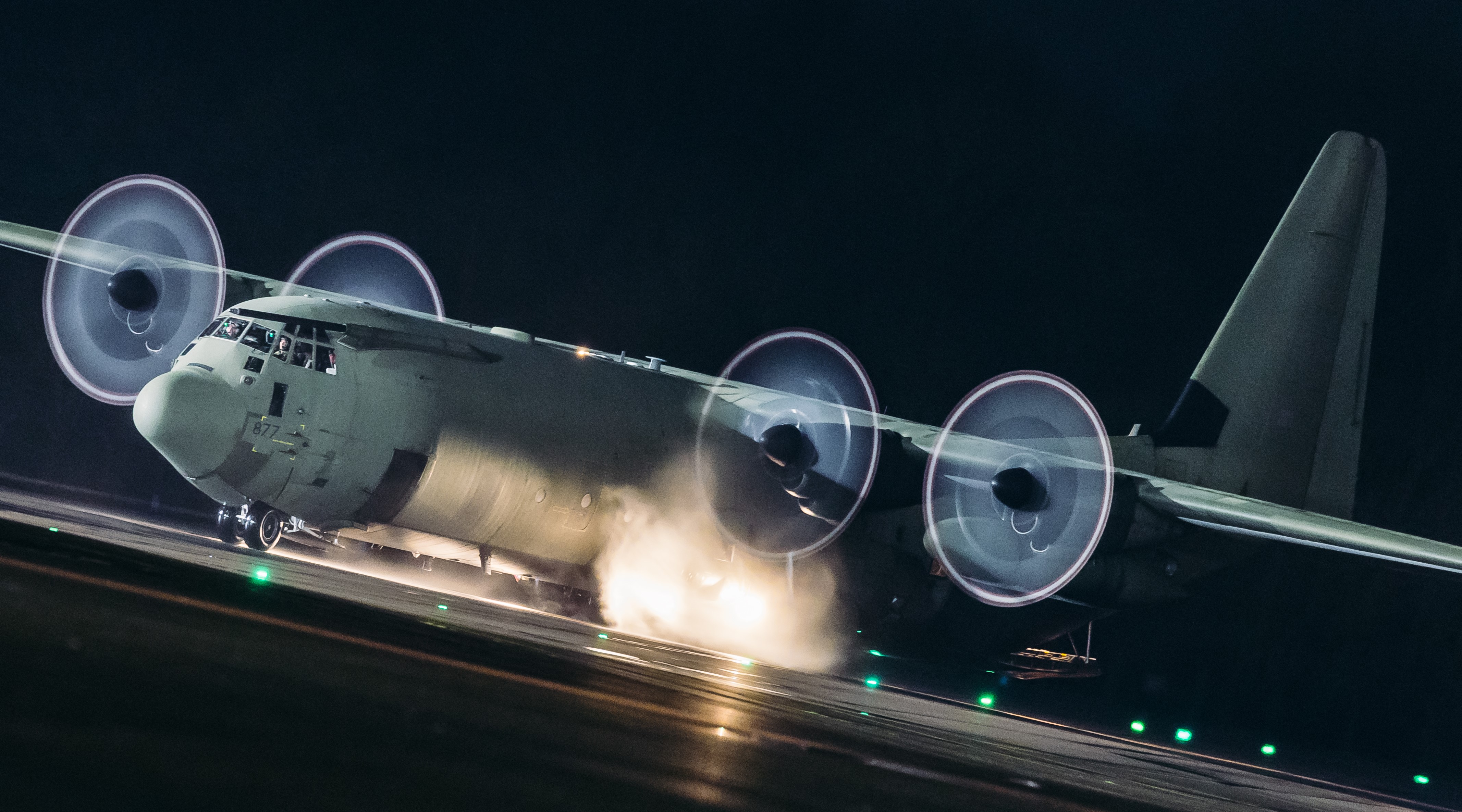 Image shows the RAF Hercules aircraft on the airfield at night.